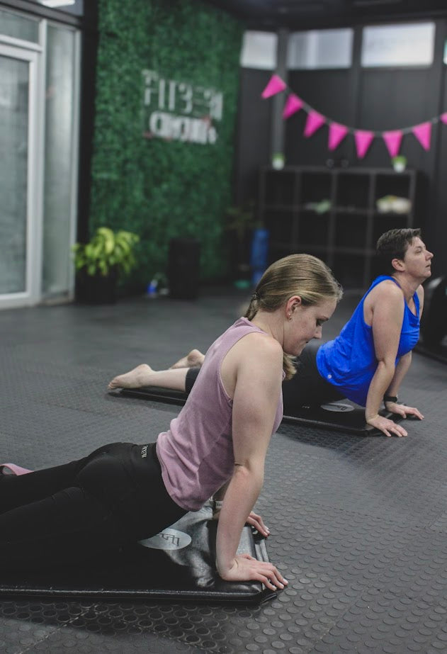 Fitberi coach and members exercising on mats in Fitberi Women zone