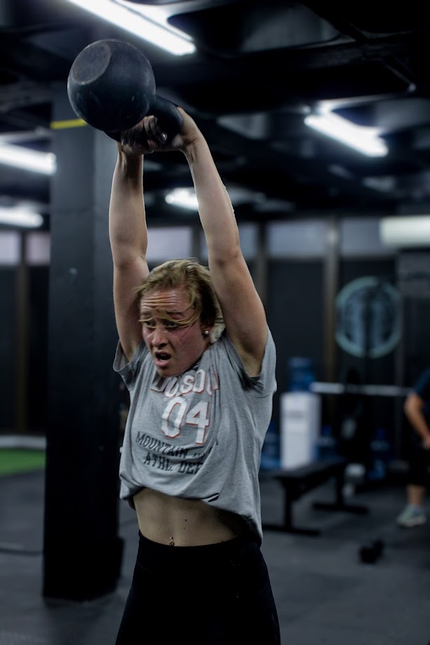 Hybrid zone member lifting a kettlebell in a gym setting
